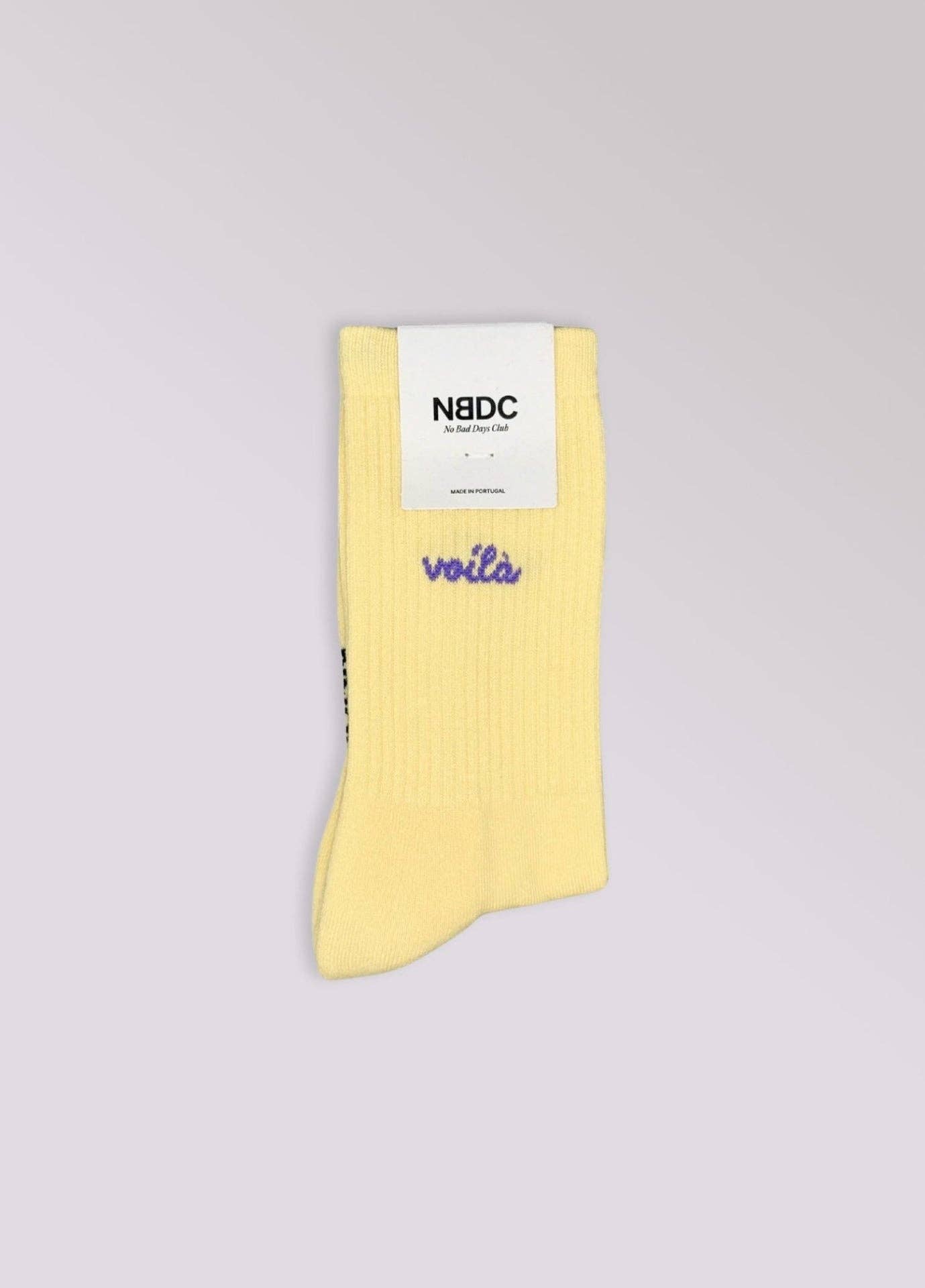 VOILÀ Statement Socken von NBDC in Gelb mit violettem Schriftzug Produktverpackung – Nohna