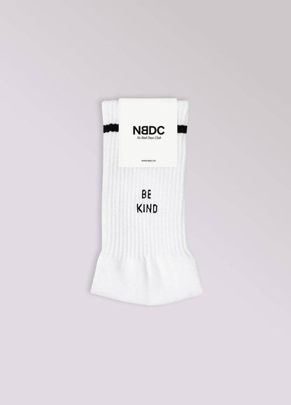 BE KIND Statement Socken von NBDC in Weiß mit schwarzem Schriftzug Produkverpackung – Nohna