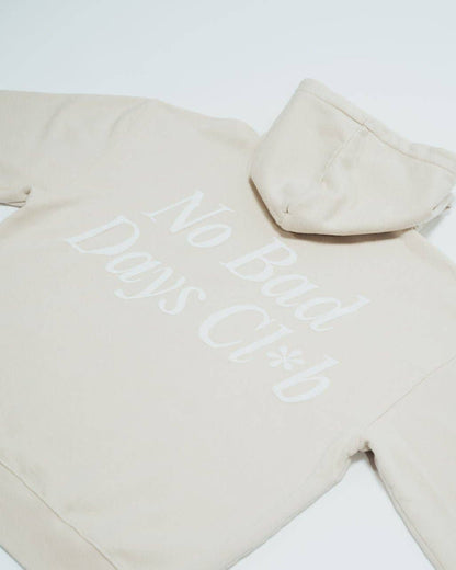 No Bad Days Club Hoodie in Sandbeige mit weißem Backprint – Rückenansicht liegend, Nohna