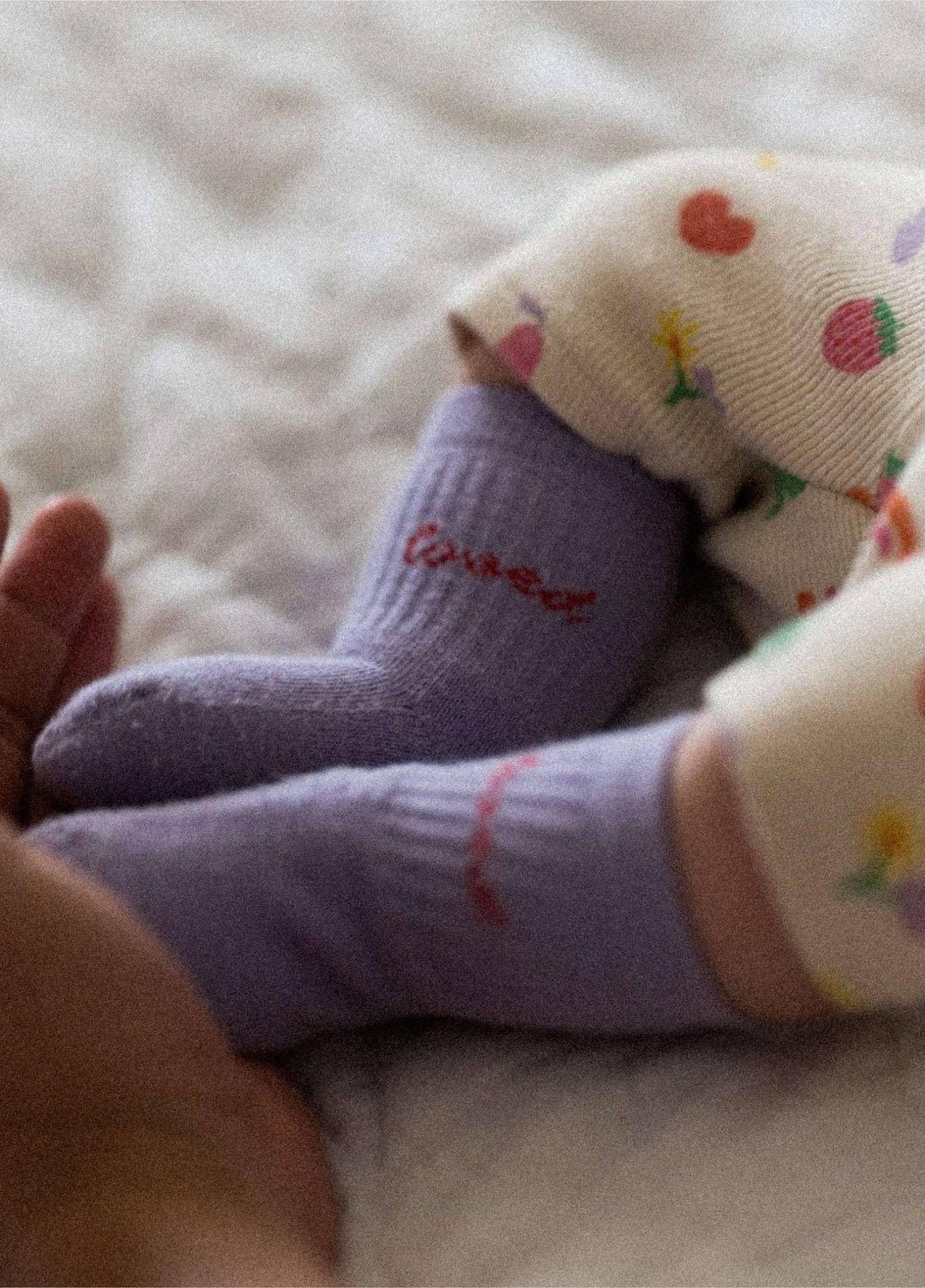 LOVED Socken in Lila mit rotem Schriftzug für Babys und Kinder von NBDC getragen – Nohna