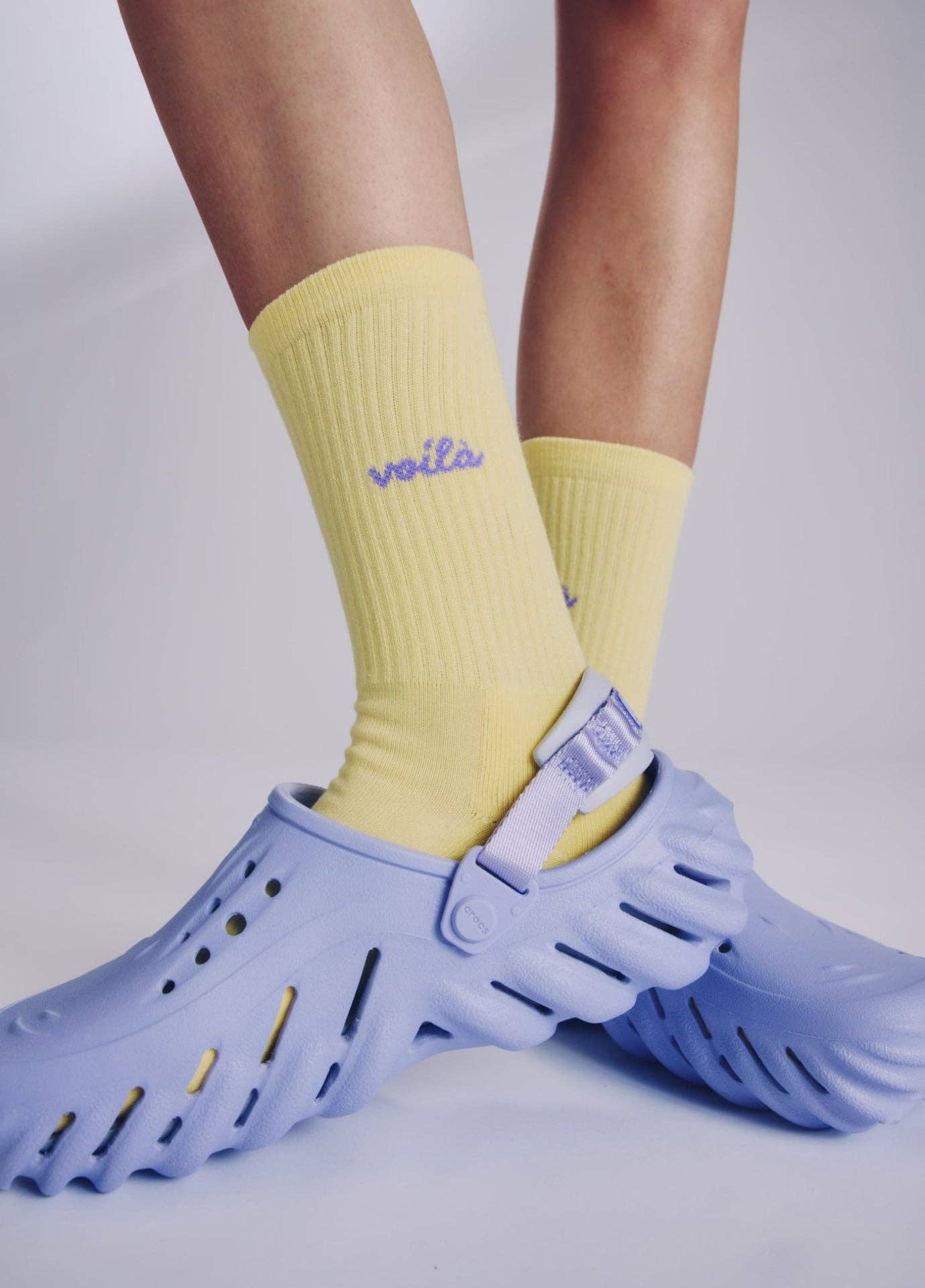 VOILÀ Statement Socken von NBDC in Gelb mit violettem Schriftzug mit Schuhe – Nohna