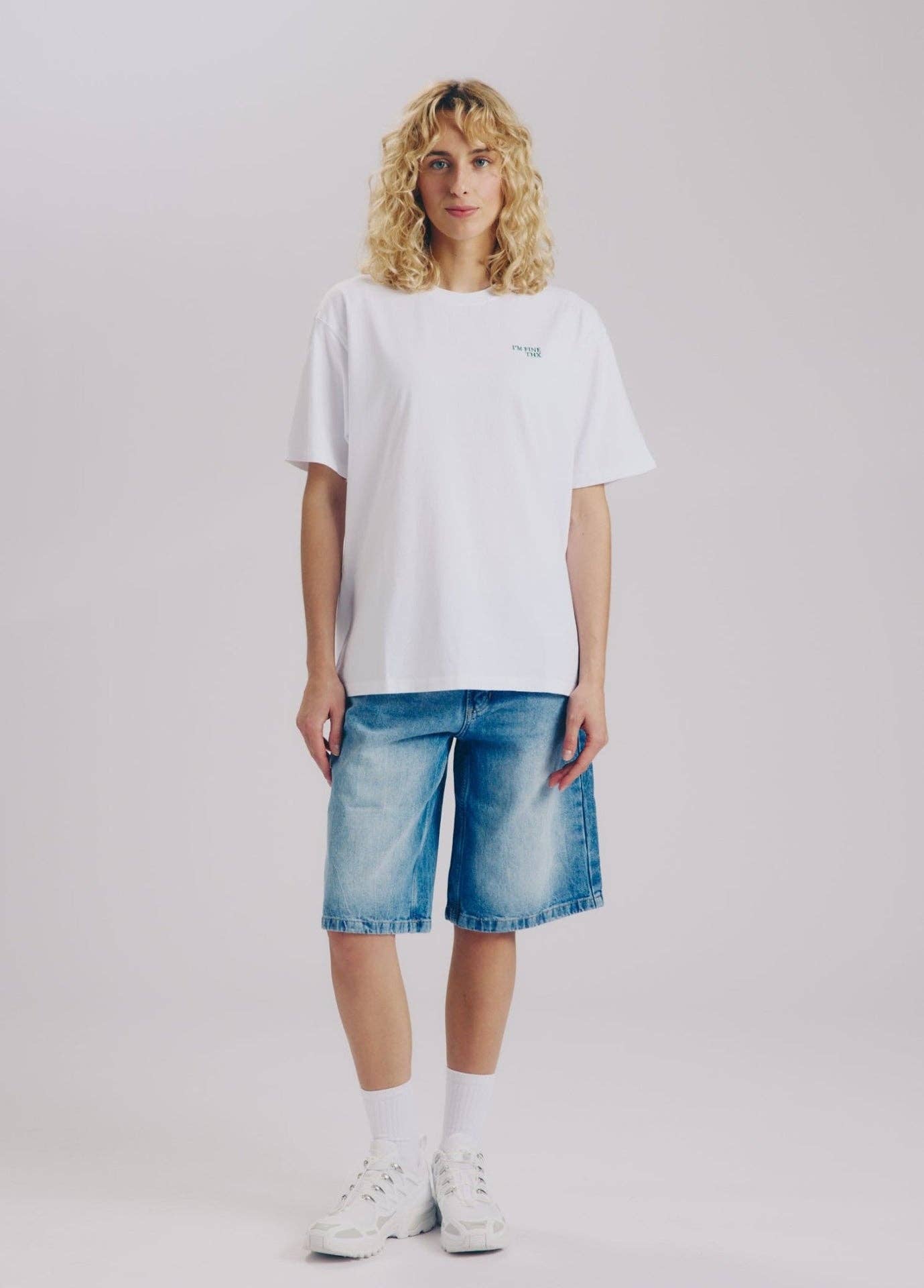 Weißes I'M FINE THX Statement T-Shirt Unisex mit grünem Schriftzug Frau mit Jeans – Nohna
